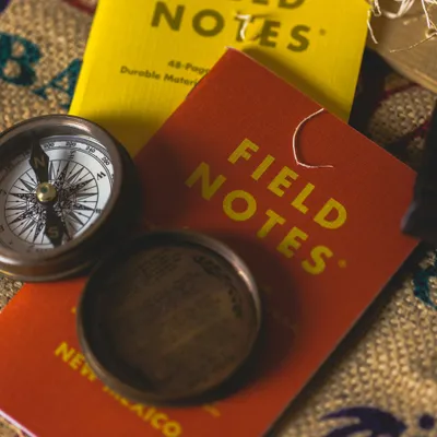 Picture of a compass and a notebook titled "Field Notes"